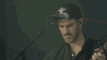 a man in a blue shirt is playing an acoustic guitar