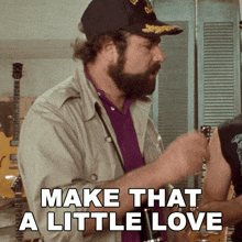 a man with a beard is playing a guitar and the caption says make that a little love