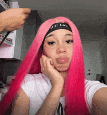 a woman with pink hair is wearing a headband with the word devil written on it