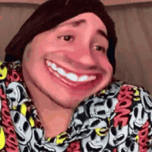 a man wearing a hat and a shirt with mickey mouse faces on it is smiling .
