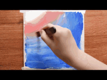 a person is painting a blue and red painting