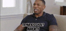 a man in a black shirt is sitting on a couch and talking to another man .