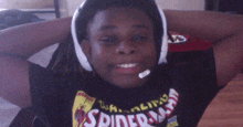 a boy wearing headphones and a spiderman shirt