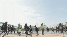 a group of people are dancing in front of a city