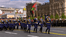 a group of soldiers marching down a street with a flag