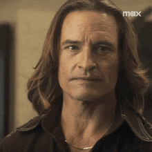 a close up of a man 's face with a max logo in the corner