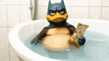 a batman duck is sitting in a bathtub holding a bag of sunkist chips