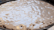 a pancake is being cooked in a pan with the words made in animotica below it