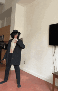 a man wearing a hat and sunglasses is standing in a room