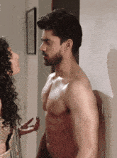a shirtless man is standing next to a woman