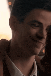 a close up of a man in a suit and tie smiling while hugging a woman .
