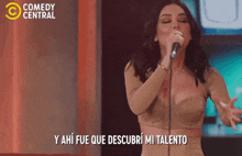 a woman singing into a microphone with the words comedy central in the corner