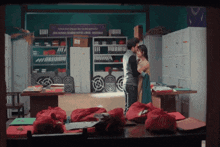 a man and woman are hugging in a room with a sign that says civil service training centre & media