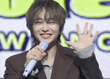 a man holding a blue microphone in front of a screen that says wing