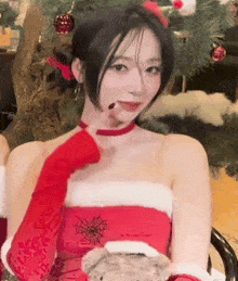 a woman in a santa costume is holding a teddy bear