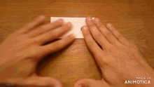 a person is holding a piece of paper with a blue circle on it and the words made in animotica on the bottom