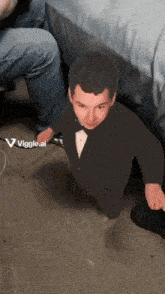 a cardboard cutout of a man in a tuxedo with the words viggle.ai visible
