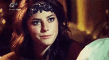 a close up of a woman wearing a headband and looking at the camera .