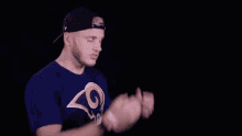 a man in a la rams shirt says it 's a catch in white letters
