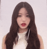 a woman with long brown hair is wearing headphones and a white top .