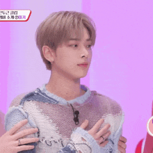a man wearing a sweater with korean writing on the chest