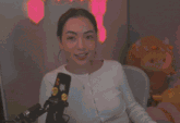 a woman in a white shirt is sitting in front of a microphone with stickers on it