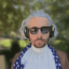 a man wearing a wig and sunglasses is wearing headphones and a scarf