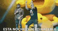 a man singing into a microphone with the words esta noche quiero hacerle