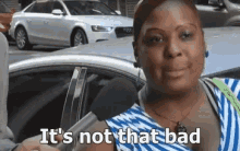 a woman is sitting in a car talking into a microphone and says it 's not that bad