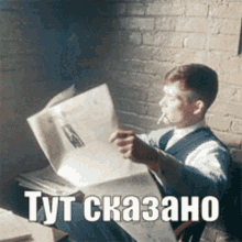a man smoking a cigarette while reading a newspaper with a foreign language caption