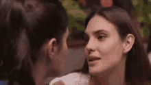two women are kissing each other on the forehead .