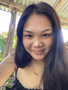 a woman wearing a black top and a necklace that says ' sally ' on it