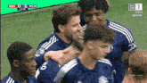 a group of soccer players are huddled together on a field with a scoreboard that says bre 0-1 mun
