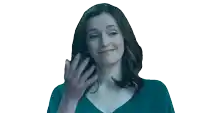 a woman in a blue shirt is smiling and talking on a cell phone