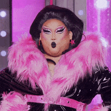 a drag queen wearing a pink fur coat