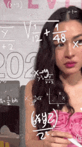a woman in a pink dress is standing in front of a whiteboard with mathematical equations on it