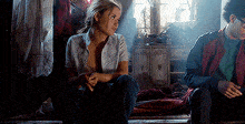 a woman is sitting next to a man in a dark room .