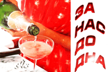 a bottle of champagne is being poured into a glass next to a red balloon