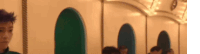 a group of people are sitting in a row in a room with a carousel in the background .