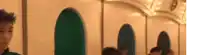 a group of people are sitting in a row in a room with a carousel in the background .