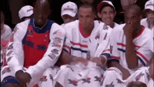 a group of men are sitting in a stadium watching a game .