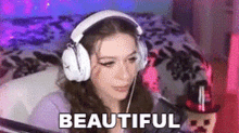 a girl wearing headphones is sitting in front of a microphone and says `` beautiful '' .
