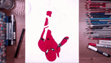 a drawing of a spider man is being completed with a faber castell eraser in the foreground