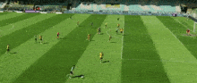 a group of soccer players are playing on a field with a stadium in the background that says ' santander '