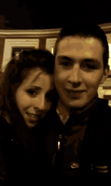 a blurry picture of a man and woman standing next to each other .