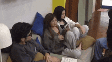 a group of people are sitting on a couch and one of them is wearing a shirt that says " i love you "