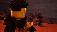two lego figures are standing next to each other in a desert
