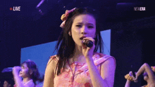 a woman is singing into a microphone on stage .