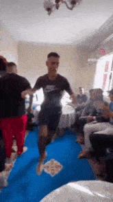 a man wearing a nike shirt is walking on a blue rug