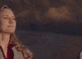 a woman wearing a crown on her head is smiling and looking to the side .